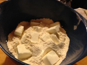 Sift together flour, baking powder, and salt. Cut shortening in with a pastry cutter. Mix in water and transfer to pie board, handling minimally.